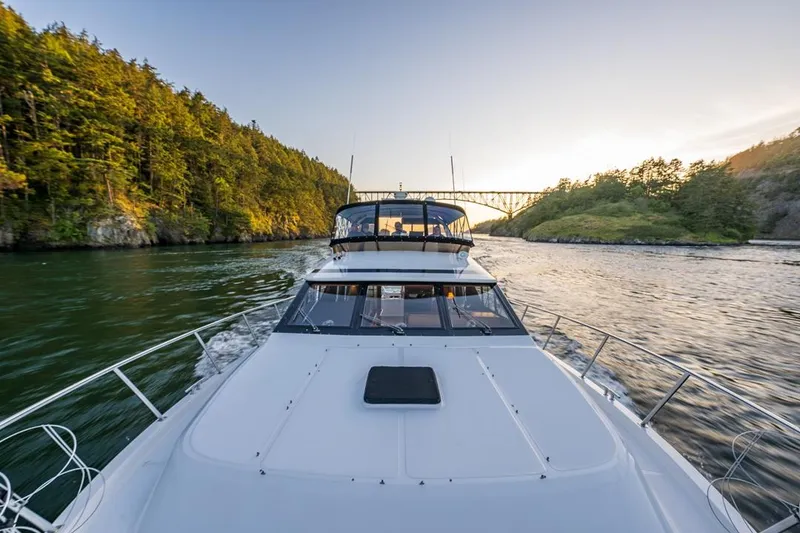 Slide: The Image of Ocean Alexander 48 Cockpit Motoryacht cruising through scenic waterway at sunset, 1990 model. - 21