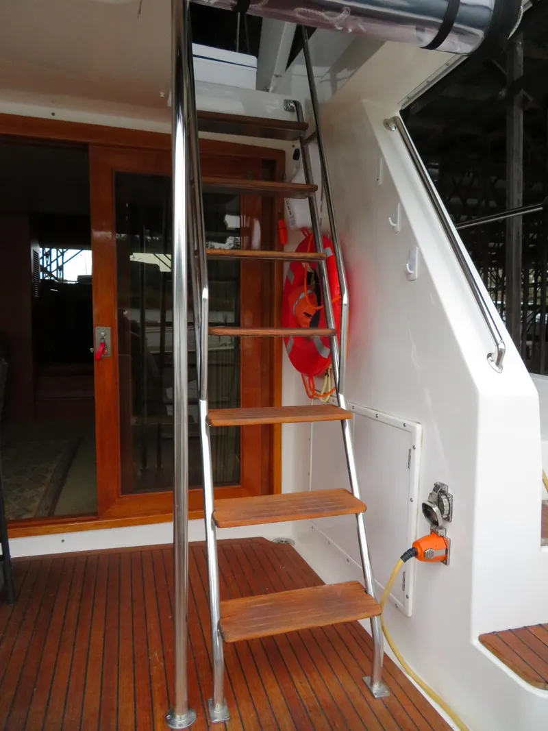 Slide: The Image of Staircase on 1990 Ocean Alexander 48 Cockpit Motoryacht with wooden steps and metal railings. - 30