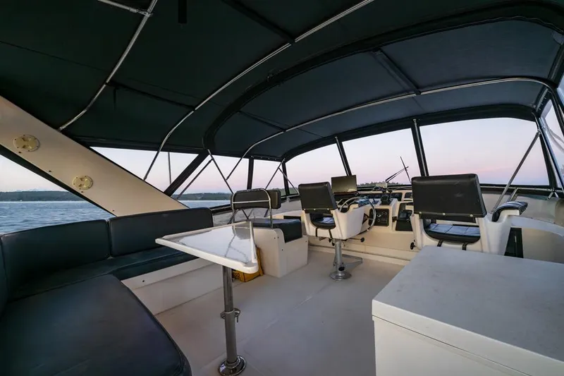 Slide: The Image of 1990 Ocean Alexander 48 Cockpit Motoryacht interior with seating and helm, overlooking water. - 32