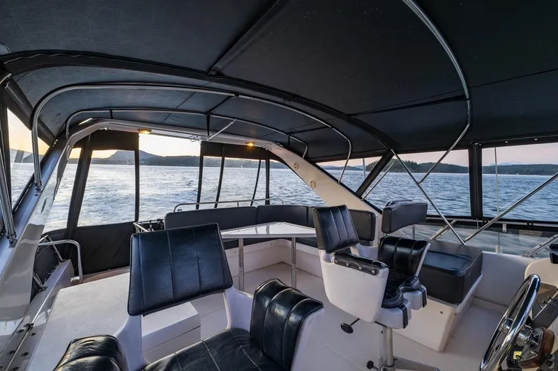 Slide: The Image of 1990 Ocean Alexander 48 Cockpit Motoryacht interior with black seating and panoramic water views. - 33