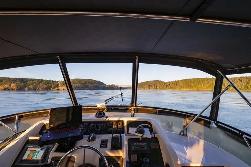 Slide: The Image of Cockpit view of 1990 Ocean Alexander 48 Motoryacht navigating scenic waters. - 34