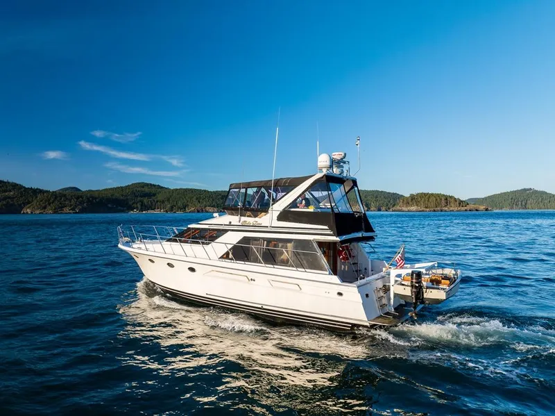Slide: The Image of 1990 Ocean Alexander 48 Cockpit Motoryacht cruising on open water under clear blue skies. - 4