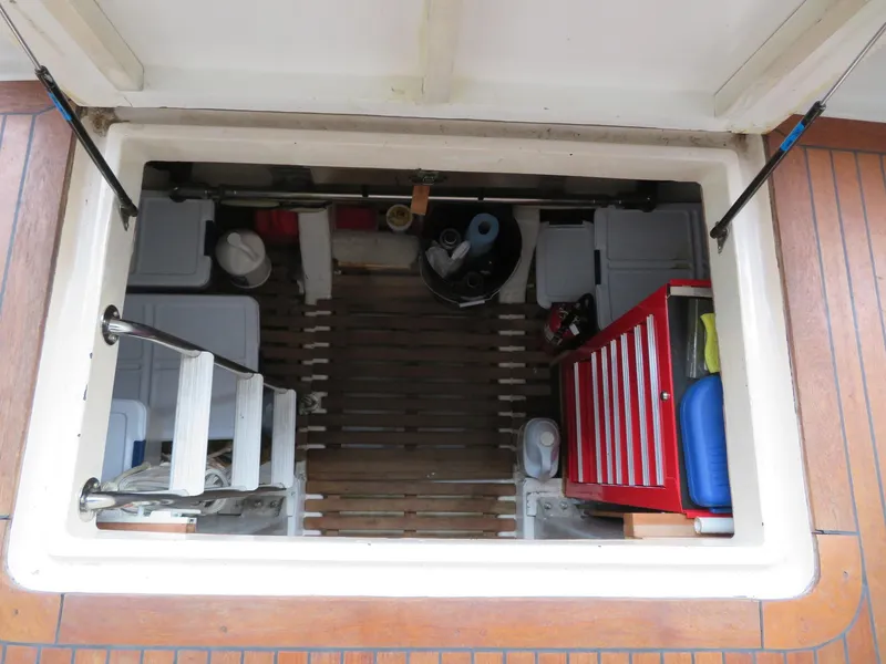 Slide: The Image of Engine room hatch of 1990 Ocean Alexander 48 Cockpit Motoryacht, showing storage and equipment. - 45