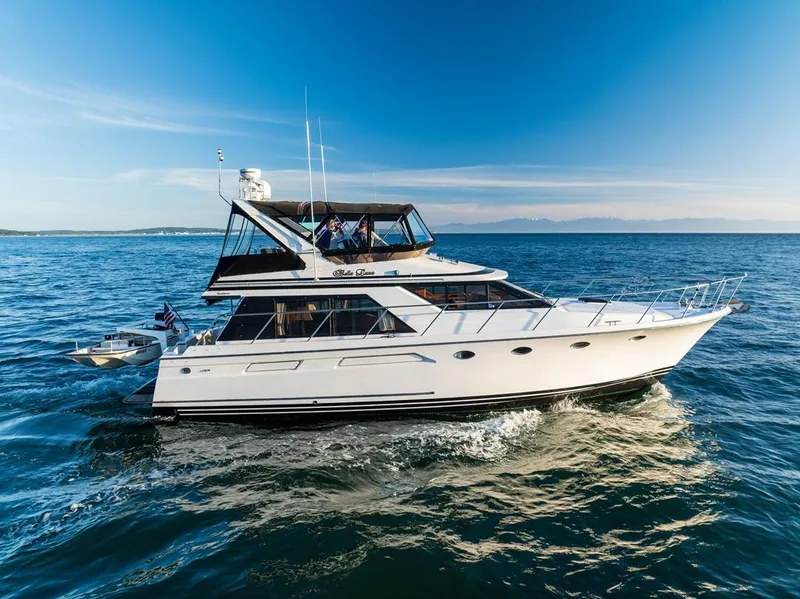 Slide: The Image of 1990 Ocean Alexander 48 Cockpit Motoryacht cruising on open water under clear skies. - 6