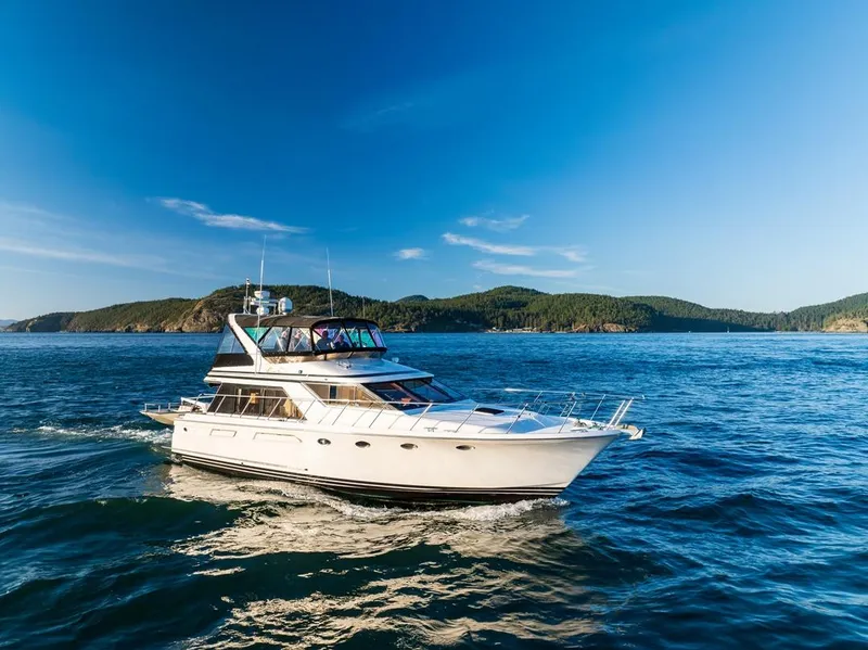Slide: The Image of 1990 Ocean Alexander 48 Cockpit Motoryacht cruising on blue ocean with scenic island backdrop. - 7