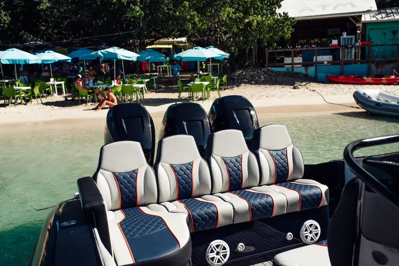 Slide: The Image of 2014 Midnight Express 37' Open boat with stylish seating near a beachside café. - 13