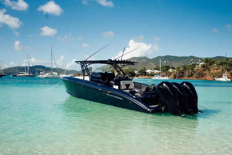 Slide: The Image of 2014 Midnight Express 37' Open boat in clear turquoise water, scenic coastal backdrop. - 2