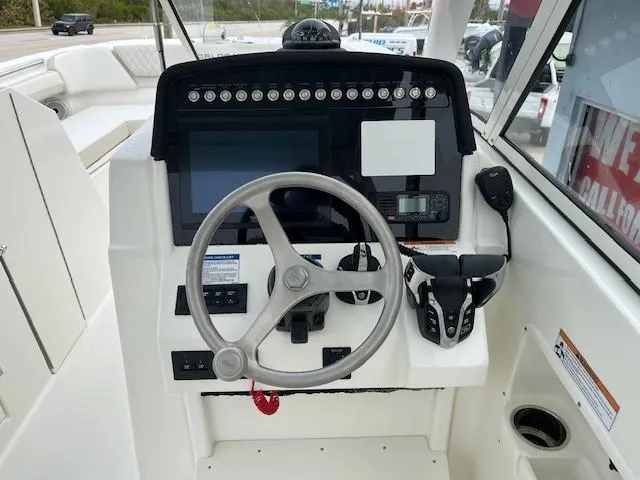 Slide: The Image of 2025 World Cat 296 DC boat dashboard with steering wheel and controls. - 5