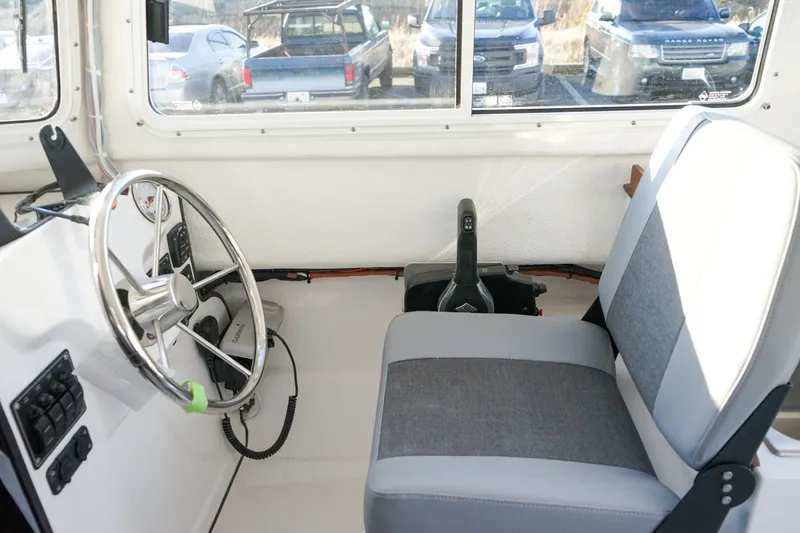 Slide: The Image of Interior of 2025 C-Dory 22' Cruiser showing steering wheel and seat. - 11