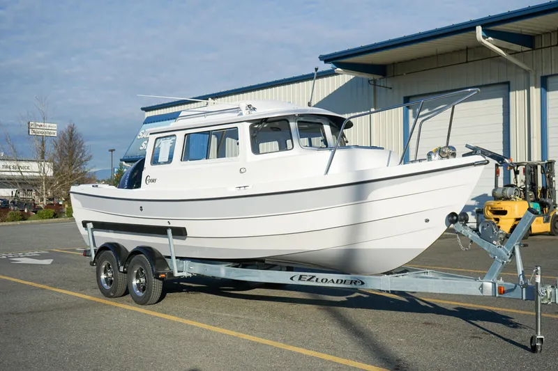 Slide: The Image of 2025 C-Dory 22' Cruiser on trailer outside a warehouse. - 3