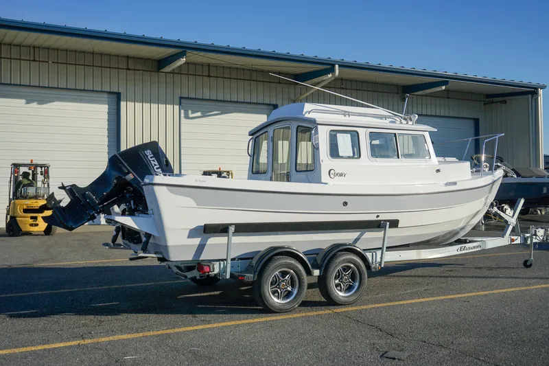 Slide: The Image of 2025 C-Dory 22' Cruiser boat on trailer, parked outside a warehouse. - 6