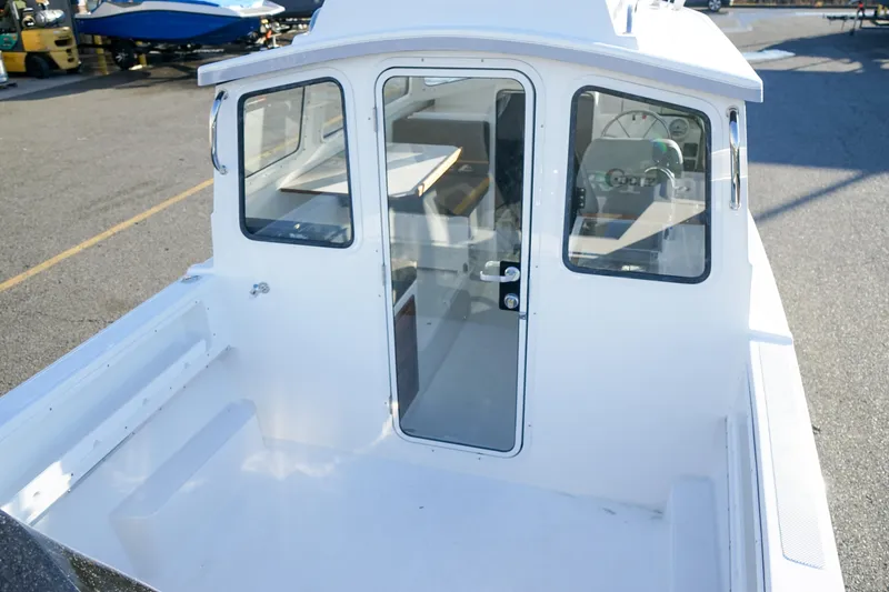 Slide: The Image of 2025 C-Dory 22' Cruiser boat, white exterior, docked, showcasing cabin entrance and windows. - 7