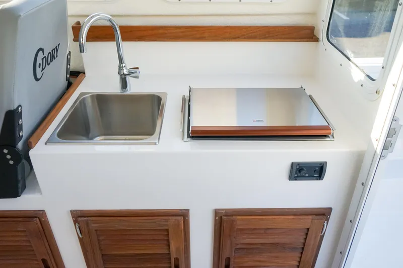 Slide: The Image of Interior of 2025 C-Dory 22' Cruiser with sink and wooden cabinets. - 9