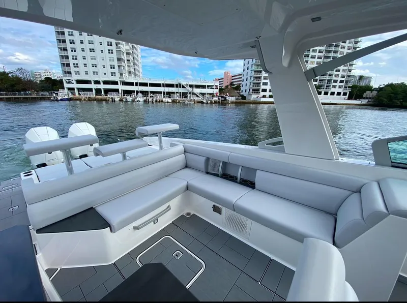 Slide: The Image of 2024 Aviara AV32 OB luxury boat interior with sleek seating, docked near waterfront buildings. - 10