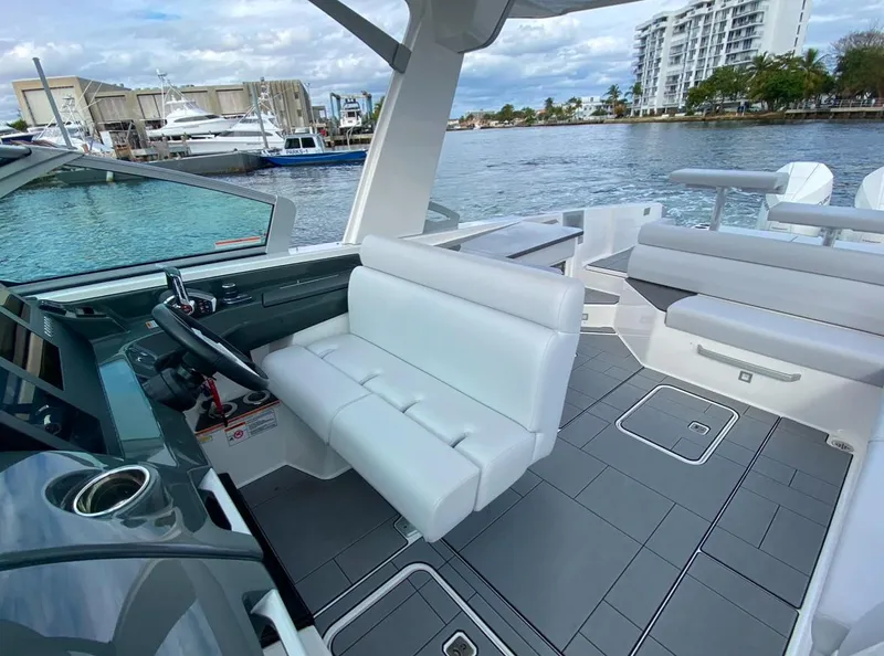 Slide: The Image of 2024 Aviara AV32 OB boat interior with modern seating and waterfront view. - 18