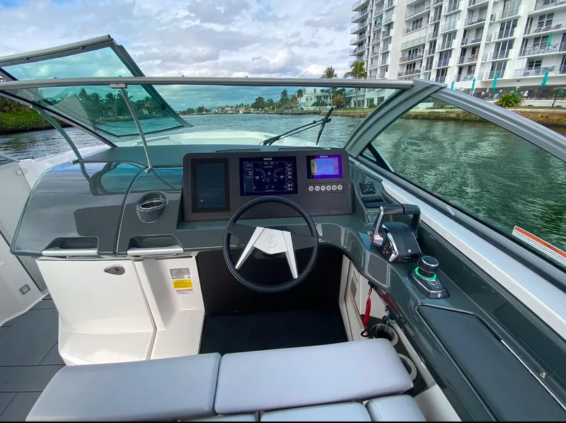 Slide: The Image of 2024 Aviara AV32 OB boat cockpit with modern controls and waterfront view. - 19