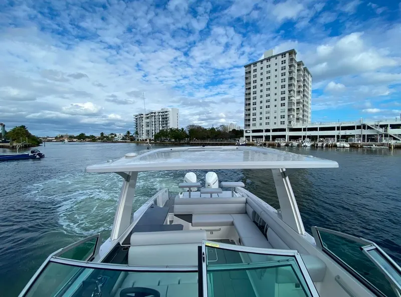 Slide: The Image of 2024 Aviara AV32 OB cruising on a scenic waterway with cityscape backdrop. - 24