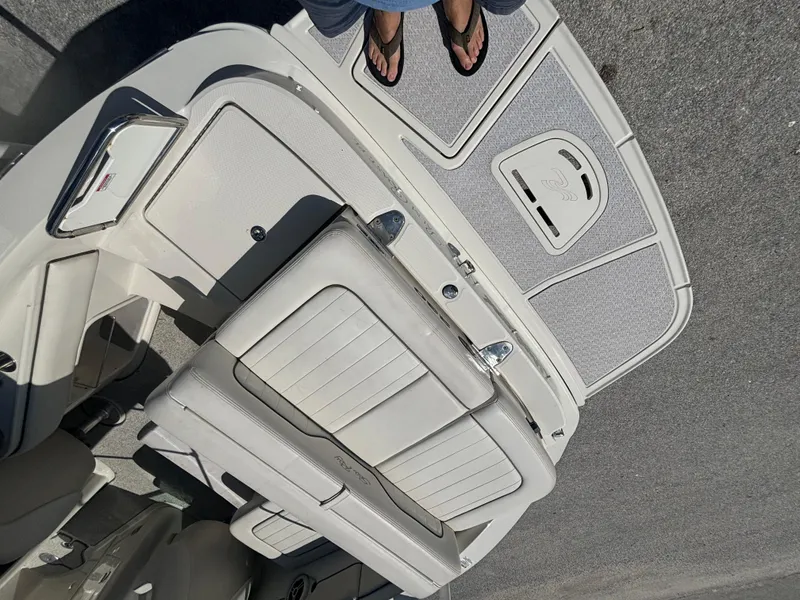 Slide: The Image of 2008 Sea Ray 230 Sundeck boat interior with white seating and deck. - 12