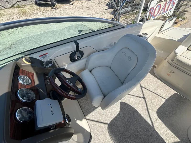Slide: The Image of 2008 Sea Ray 230 Sundeck cockpit with steering wheel and Garmin device. - 16