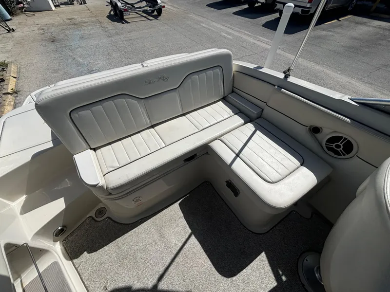 Slide: The Image of 2008 Sea Ray 230 Sundeck interior seating with white upholstery and speaker. - 17