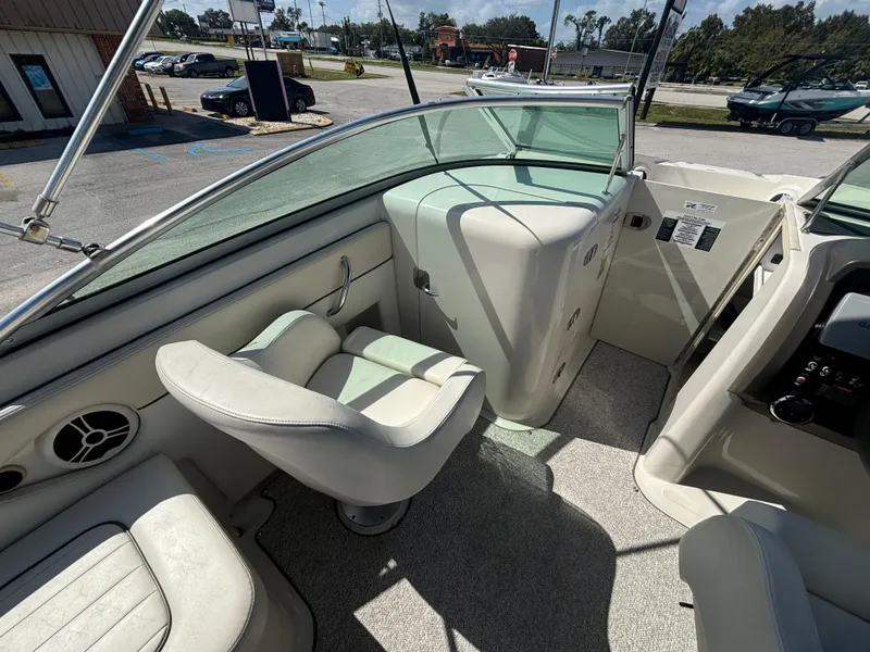 Slide: The Image of 2008 Sea Ray 230 Sundeck interior with seating and dashboard, parked outdoors. - 21