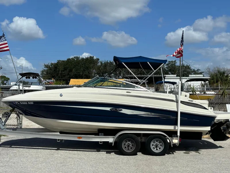 Slide: The Image of 2008 Sea Ray 230 Sundeck boat on trailer, blue and white, with American flags. - 3