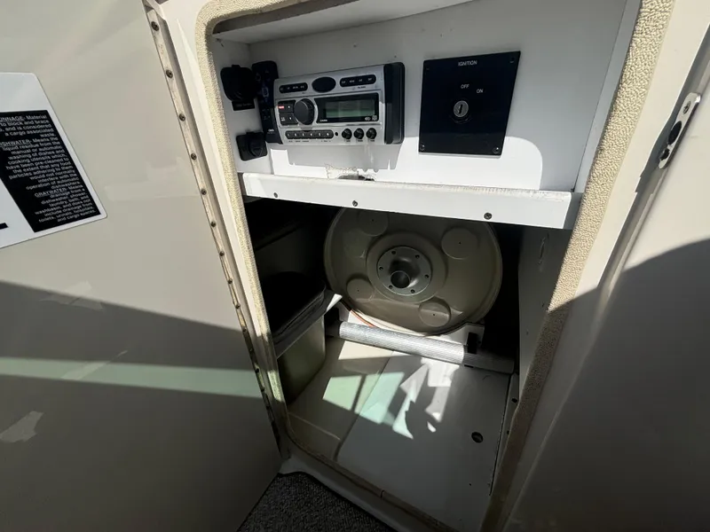 Slide: The Image of 2008 Sea Ray 230 Sundeck storage compartment with stereo system and equipment. - 30