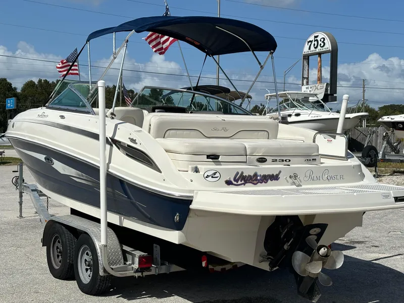 Slide: The Image of 2008 Sea Ray 230 Sundeck boat on trailer with American flags and blue canopy. - 5