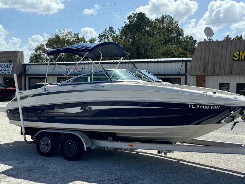 Slide: The Image of 2008 Sea Ray 230 Sundeck boat on trailer, parked outdoors under a blue sky. - 7