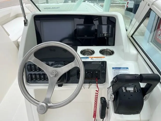 Slide: The Image of 2025 World Cat 230 SD boat dashboard with steering wheel and control panel. - 4