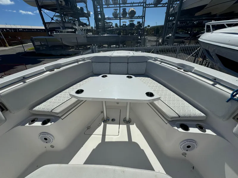 Slide: The Image of 2021 Sea Fox 328 Commander boat interior with seating and table in marina setting. - 4