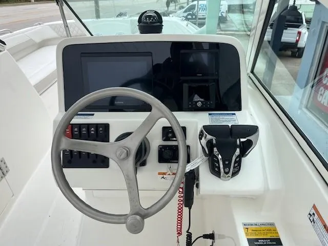 Slide: The Image of 2025 World Cat 230 DC boat dashboard with steering wheel and control panel. - 5