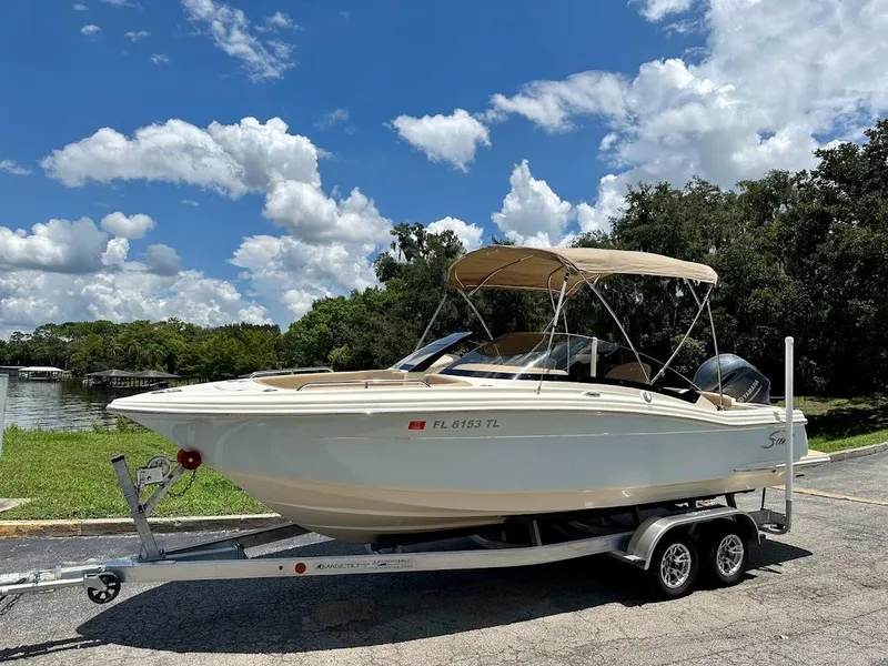 Slide: The Image of 2023 Scout 215 Dorado boat on trailer under blue sky with clouds. - 1