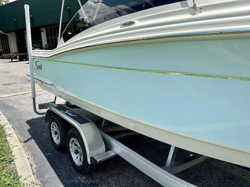 Slide: The Image of 2023 Scout 215 Dorado boat on a trailer, parked outdoors. - 11