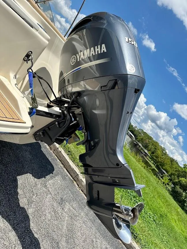 Slide: The Image of 2023 Scout 215 Dorado with Yamaha outboard motor, parked outdoors on a sunny day. - 16