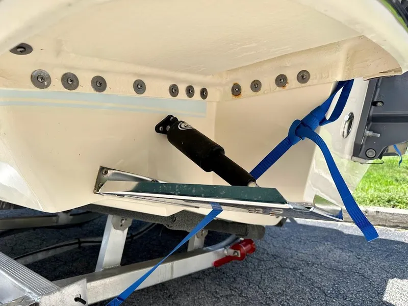 Slide: The Image of 2023 Scout 215 Dorado boat hull with trim tab and blue strap on trailer. - 20