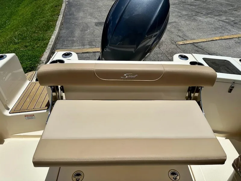 Slide: The Image of 2023 Scout 215 Dorado boat seat with beige upholstery and motor view. - 23