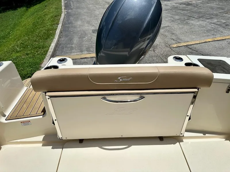 Slide: The Image of 2023 Scout 215 Dorado boat with beige seating and motor, docked on a sunny day. - 24