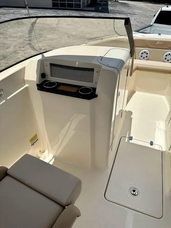Slide: The Image of 2023 Scout 215 Dorado boat interior with seating and console, featuring cup holders and speakers. - 30