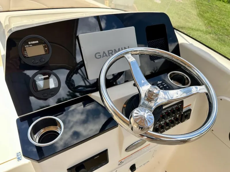 Slide: The Image of 2023 Scout 215 Dorado boat dashboard with Garmin display and steering wheel. - 35
