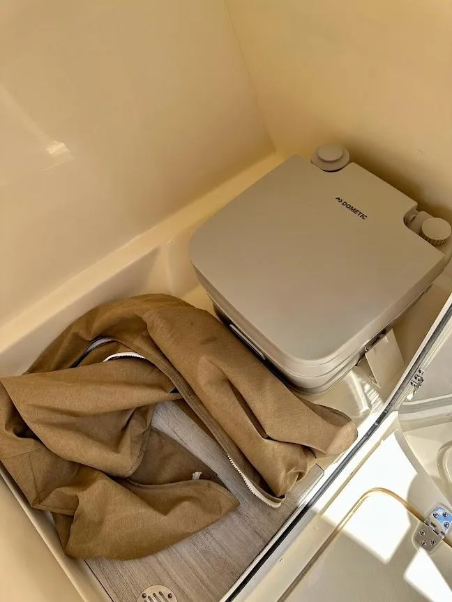 Slide: The Image of 2023 Scout 215 Dorado boat interior with portable toilet and brown fabric. - 39