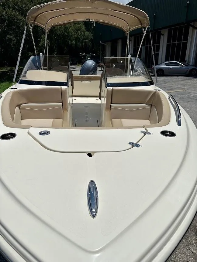 Slide: The Image of 2023 Scout 215 Dorado boat with beige seating and canopy, parked outdoors. - 8
