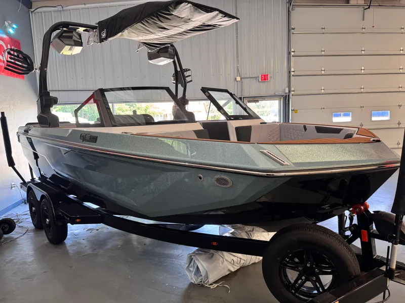 Slide: The Image of 2025 Nautique Super Air Nautique GS20 boat in a garage on a trailer. - 1