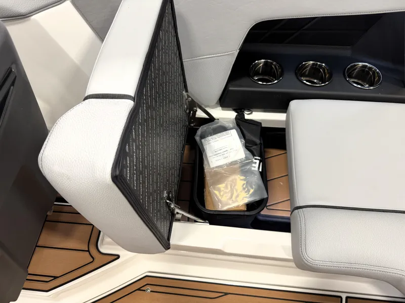 Slide: The Image of 2025 Nautique Super Air Nautique GS20 boat seat storage compartment with cup holders. - 17