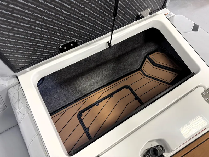 Slide: The Image of 2025 Nautique Super Air Nautique GS20 storage compartment with open lid, showcasing interior design. - 18