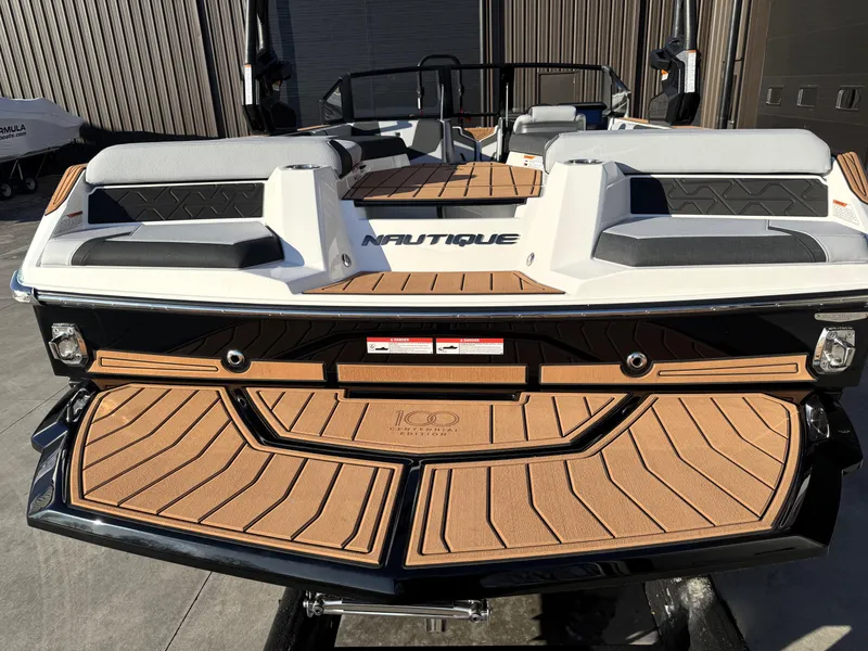 Slide: The Image of 2025 Nautique Super Air Nautique GS20 boat, rear view, featuring sleek design and cushioned seating. - 3