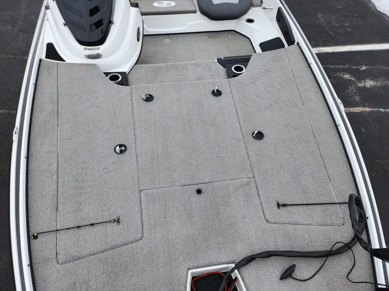 Slide: The Image of 2016 Nitro Z18 boat deck with gray carpeting and storage compartments. - 18