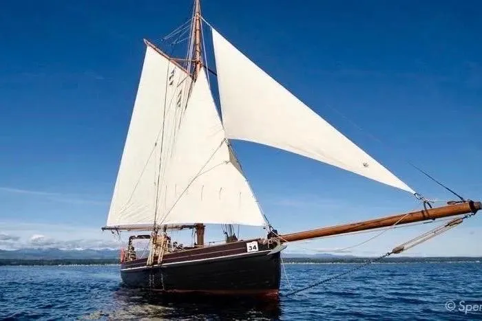 Slide: The Image of Vintage 1903 Morecambe Bay Prawner sailboat on open water under clear blue sky. - 3