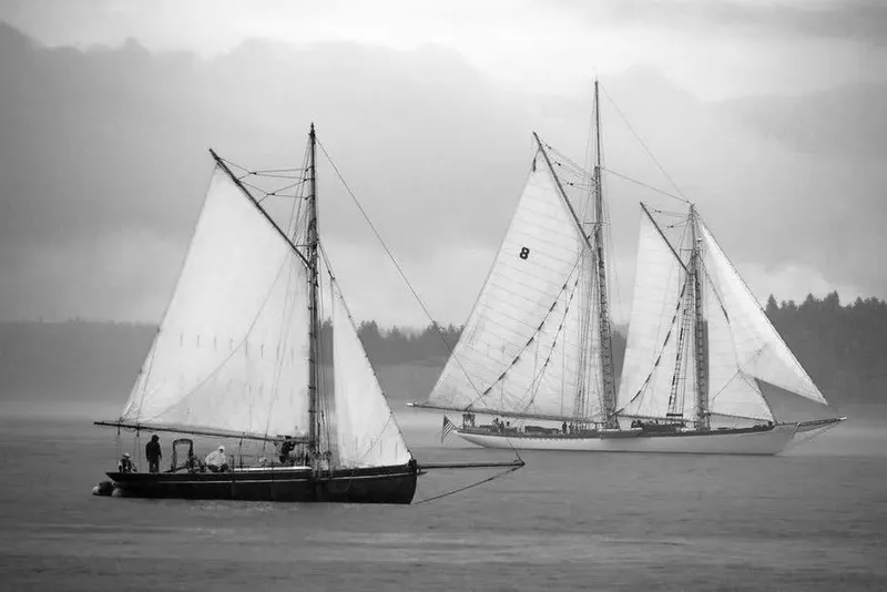 Slide: The Image of Two vintage sailboats on misty water, featuring a 1903 Morecambe Bay Prawner 38'. - 5