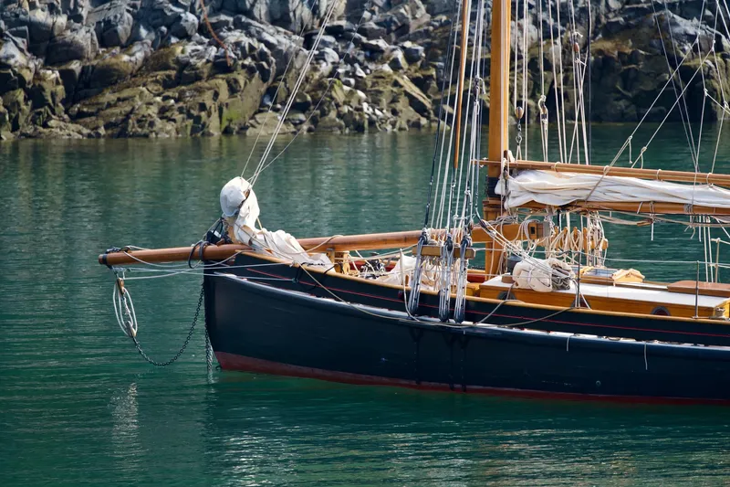 Slide: The Image of Vintage 1903 Morecambe Bay Prawner sailboat docked in calm waters, showcasing classic wooden craftsmanship. - 6